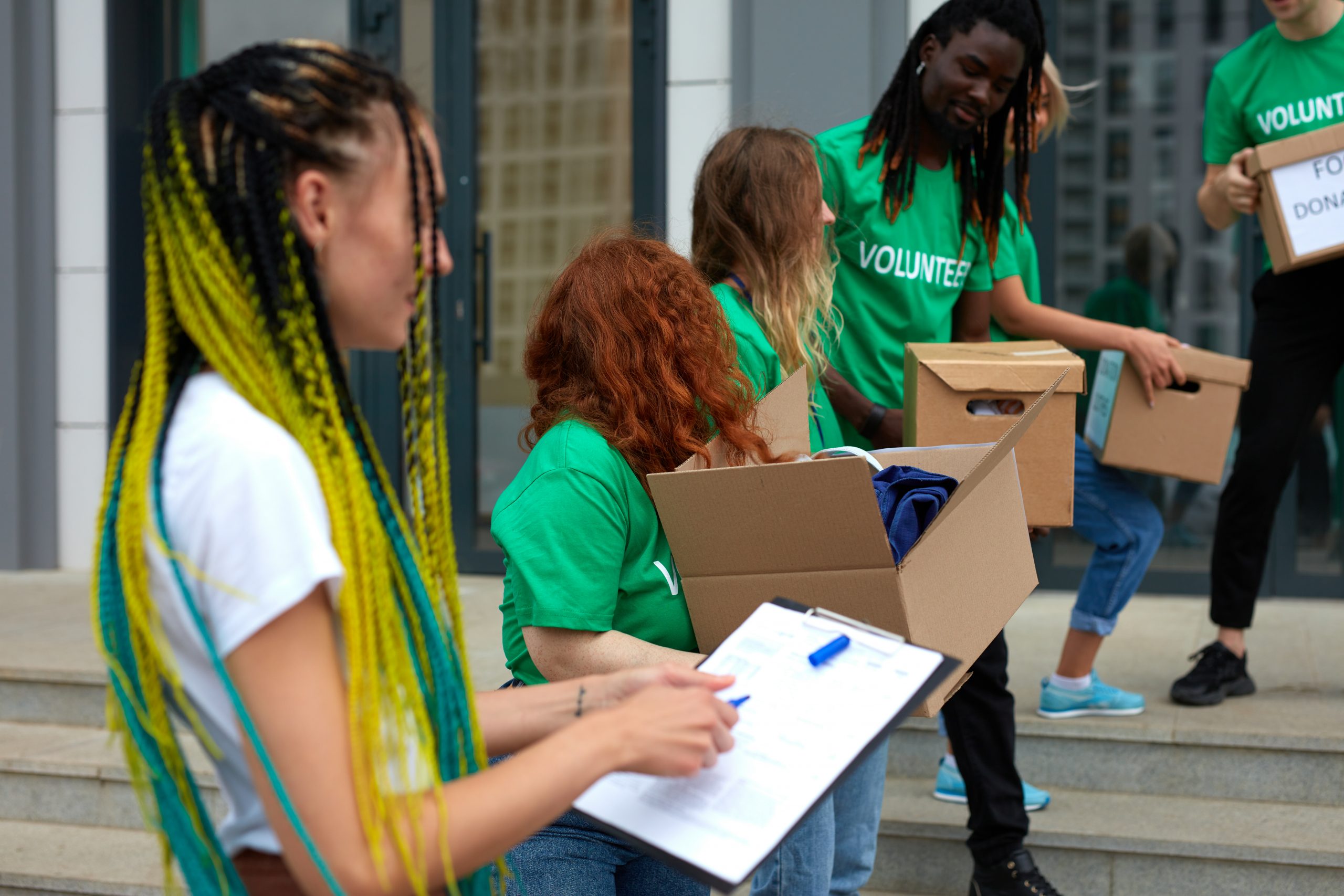 diverse volunteers packing, collecting humanitarian aid in donation box